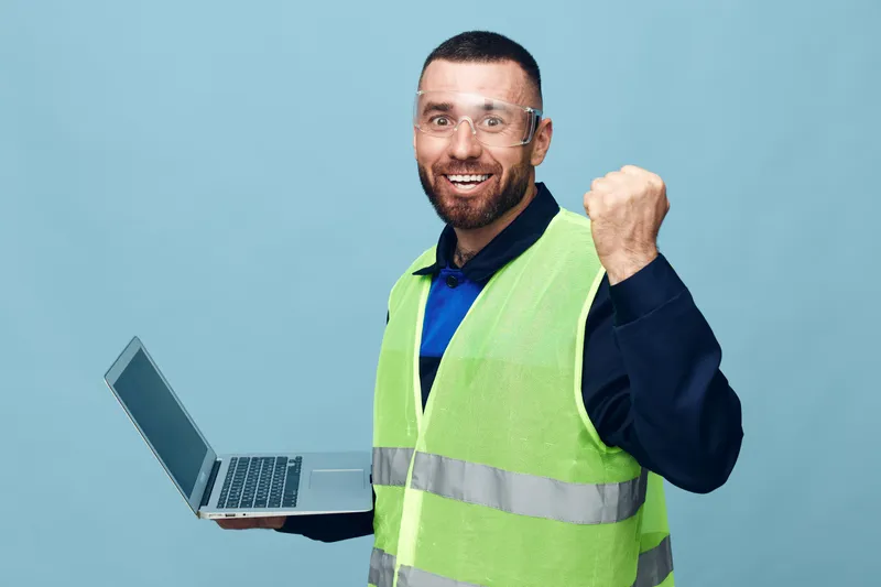 Взрослый мужчина работает за ноутбуком на жёлтом фоне
