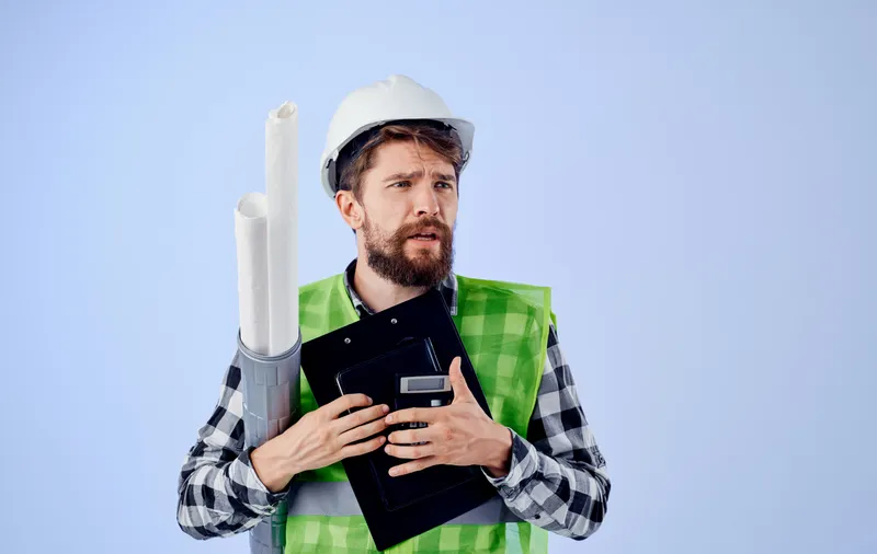 Инженер в белой каске, чертежи, документы, строительство, профессионал