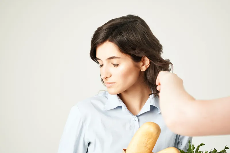 Улыбающаяся женщина с пакетом продуктов в супермаркете