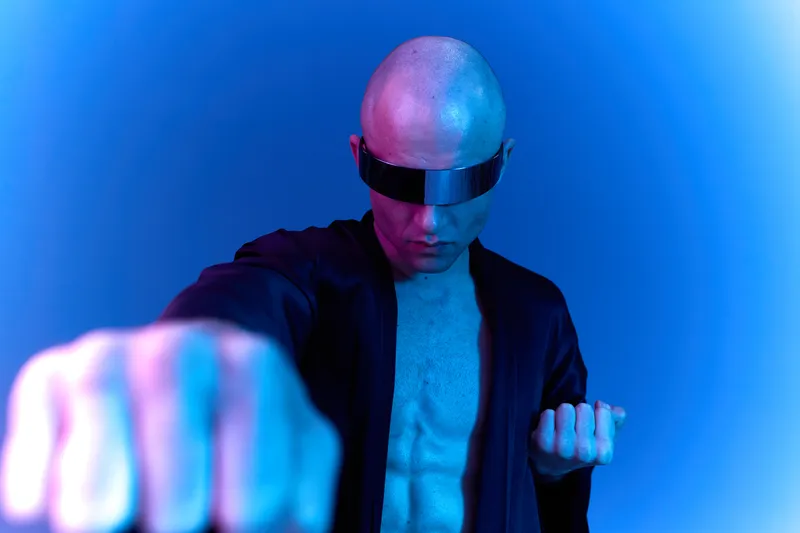 Futuristic man wearing sunglasses, striking a powerful pose with a focus on strength and energy. The vibrant colors enhance the dynamic atmosphere of the image.