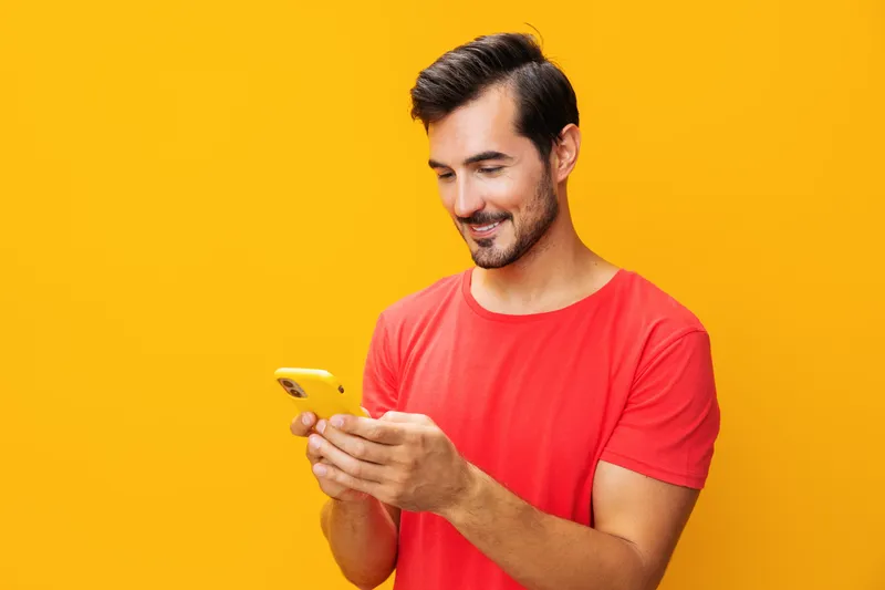 Улыбающийся мужчина в очках со смартфоном