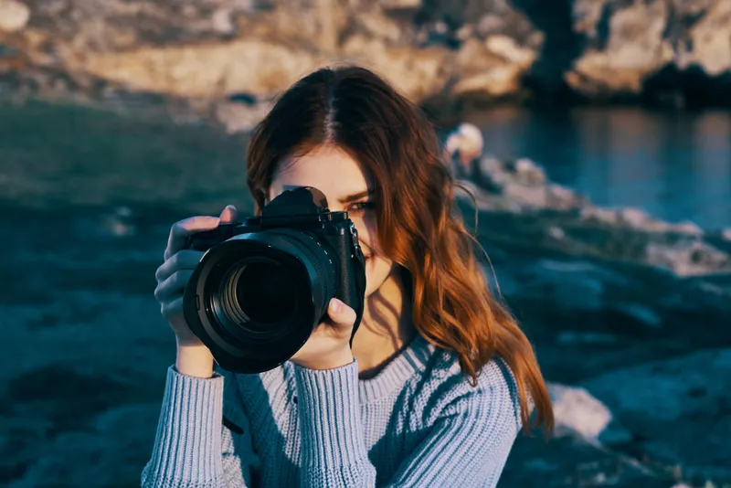 Женщина-фотограф на фоне природы, скалистые горы, приключение
