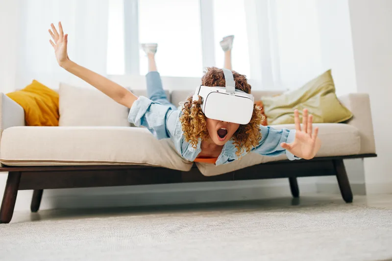 Виртуальная реальность: радостное indoor-развлечение женщины в современной гостиной