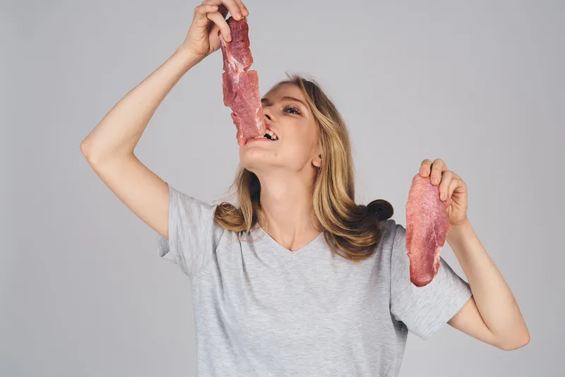 Эмоциональная женщина с продуктами в руках на сером фоне, еда, модель, обрезанный вид