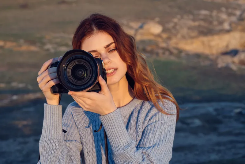 Женщина-турист с фотоаппаратом наслаждается пейзажем и природой во время отпуска и путешествия
