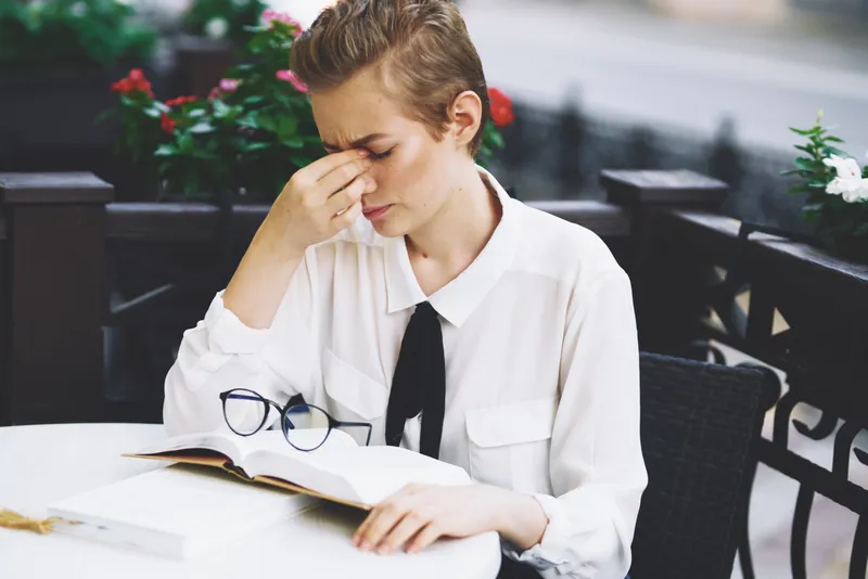Женщина читает книгу за столиком в ресторане