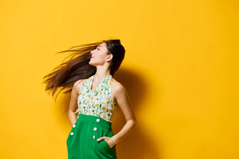 Позитивная молодая женщина в модном желтом наряде, модель, отдыхающая на природе