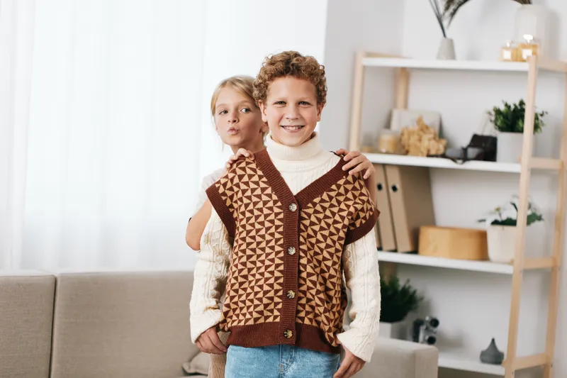 Authentic scene of children at home playing together, capturing genuine smiles, creativity, and a lifestyle moment in a cozy living room filled with soft light, warm textures, and friendly energy.