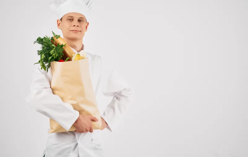 Шеф-повар с сумкой для продуктов занимается приготовлением пищи и обслуживанием