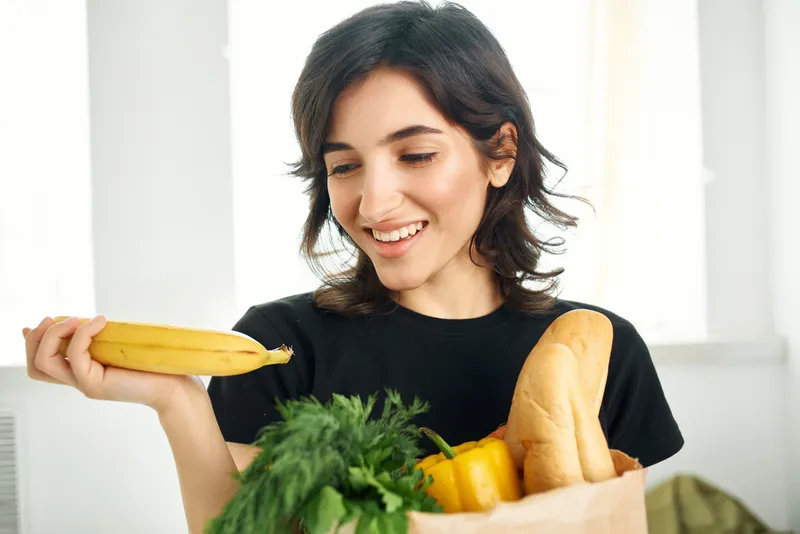 Брюнетка-домохозяйка с сумкой продуктов из супермаркета — полезная еда