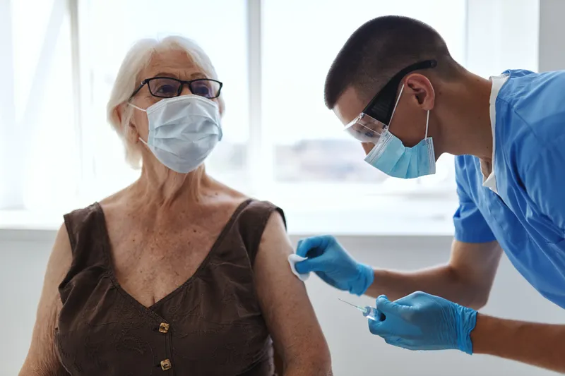 Врач и пациент в больнице обсуждают вакцинный паспорт от COVID-19