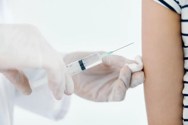 Врач делает укол в плечо, вакцинация для здоровья