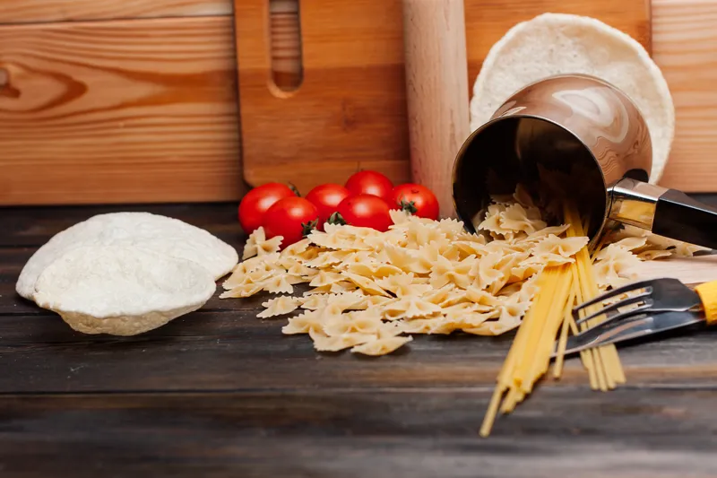 Итальянская паста, приготовление на кухне, деревянный стол, ингредиенты, помидоры черри