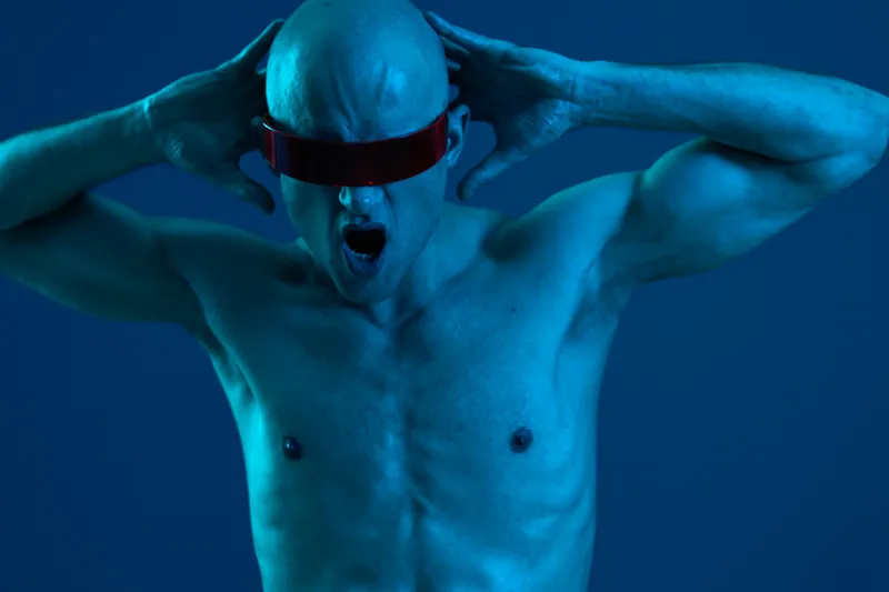 Energetic man expressing excitement with a vibrant blue lighting, showcasing a modern futuristic style that captivates attention and evokes thrill.