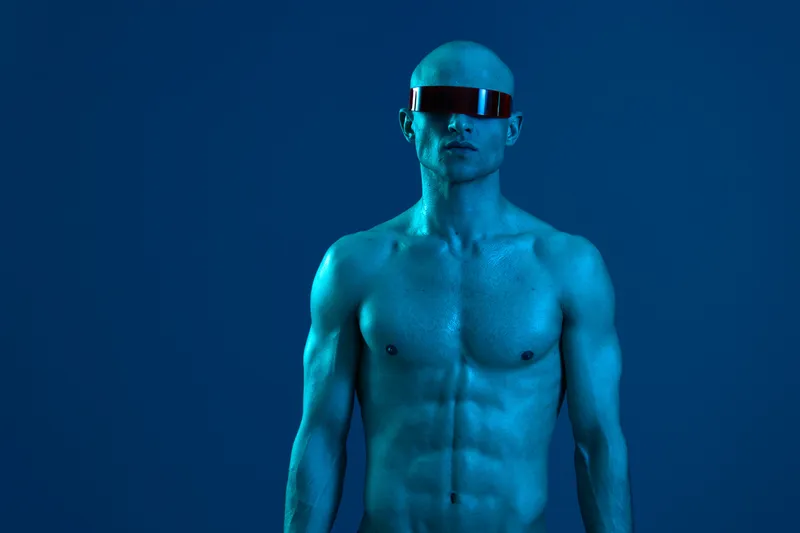 Strong man with futuristic sunglasses in blue light highlighting his muscular physique, creating an impactful and modern atmosphere with no color distractions.
