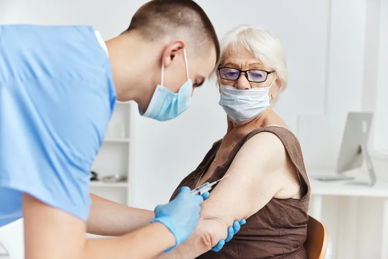 Пациент и врач обсуждают паспорт вакцинации, лечение пациента