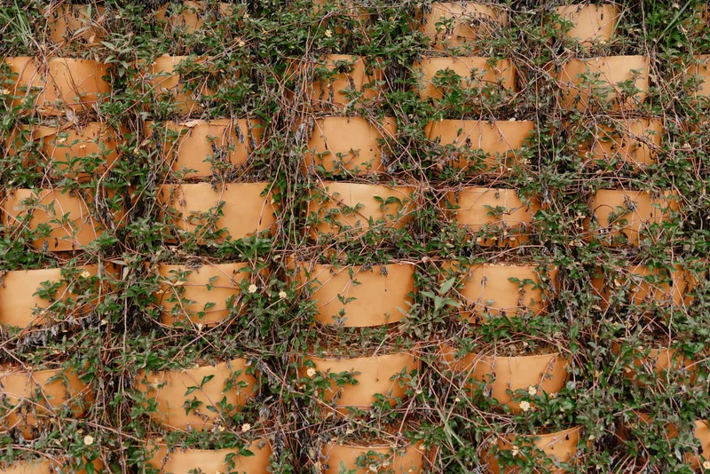 Textured pattern of old ceramic pots covered with green vines, showcasing nature s beauty and resilience in a harmonious blend of earthy colors