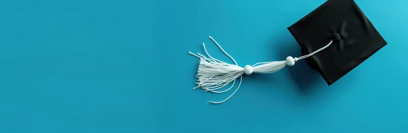 Выпускная шапочка с кисточкой на синем фоне, символизирующая академические достижения и успех в образовании
