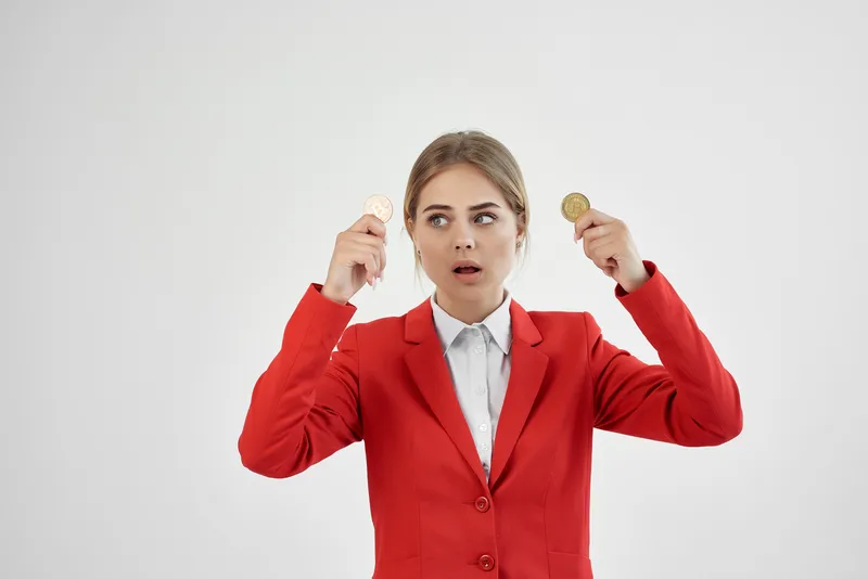 Женщина в красной куртке с золотой монетой Bitcoin на изолированном фоне