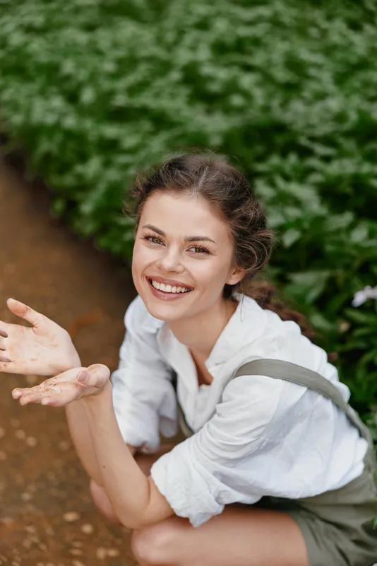 Smiling young woman in casual outfit enjoying nature with green background, expressing joy and positivity during spring season