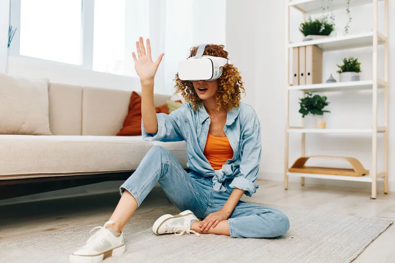 Виртуальная реальность: женщина в современных VR-очках с радостью погружается в футуристический опыт в современной гостиной