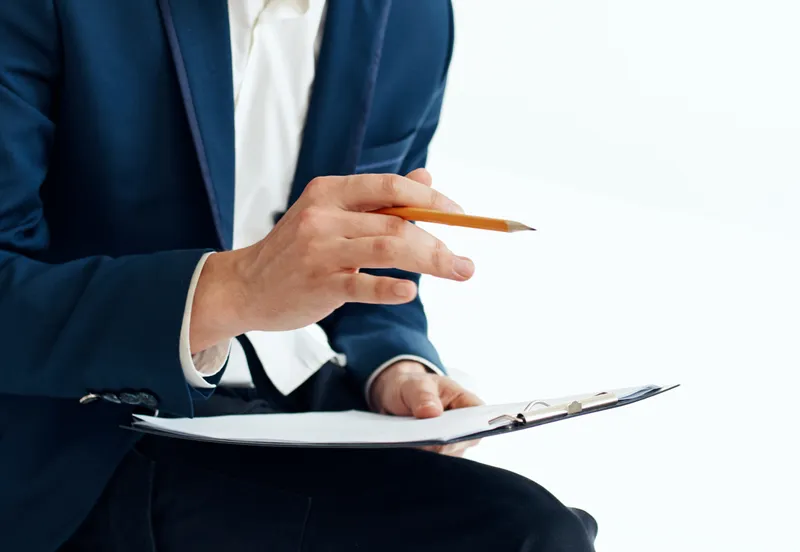 Бизнесмен с документами на коленях