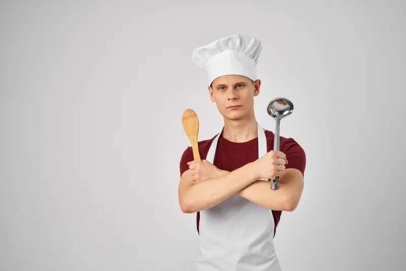 Повар-мужчина, кухонные инструменты, белый фартук, светлый фон
