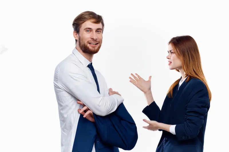 Мужчина и женщина, коллеги по работе, общаются в офисе, обсуждая финансовые вопросы