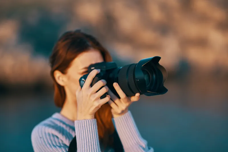 Женщина-туристка с фотоаппаратом на природе