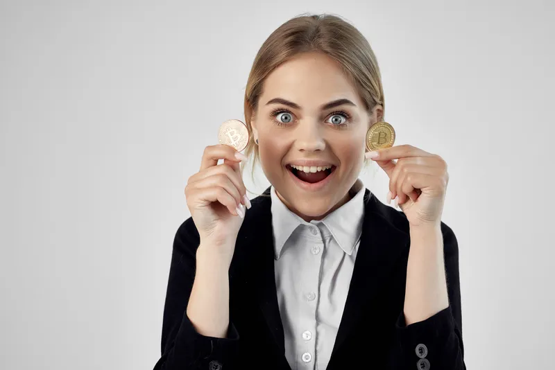 Бизнесвумен держит в руках биткоин-криптовалюту на изолированном фоне