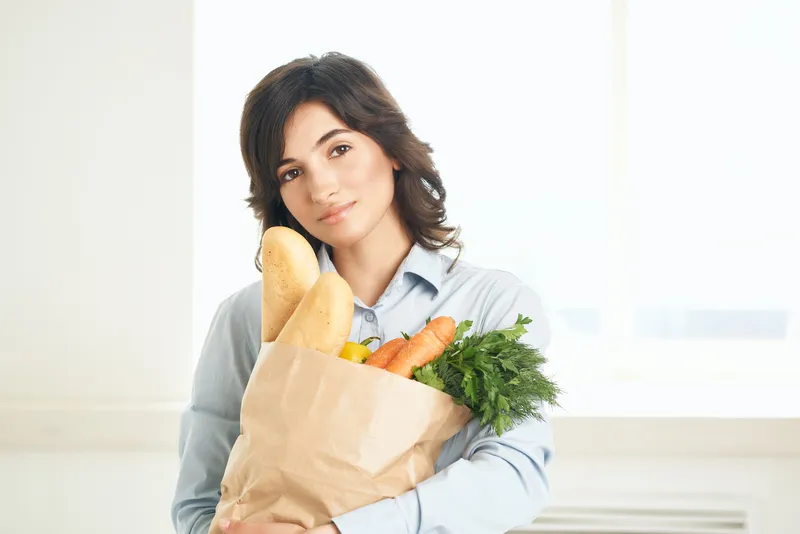 Милый брюнетка выбирает продукты в супермаркете, ведя здоровый образ жизни