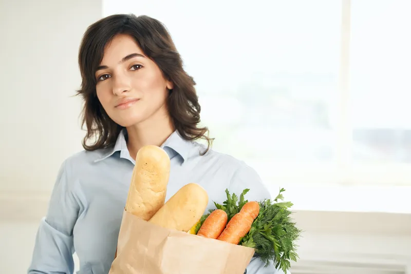 Женщина с пакетом продуктов из супермаркета