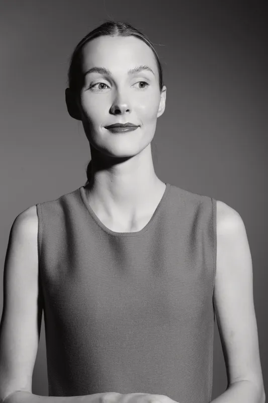 Portrait of a fair skinned Caucasian woman with slicked back hair wearing a sleeveless top in black and white studio lighting. Concept for fashion, beauty, and elegance.