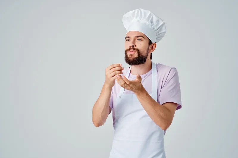 Эмоциональный шеф-повар жестикулирует руками во время работы в ресторанной индустрии
