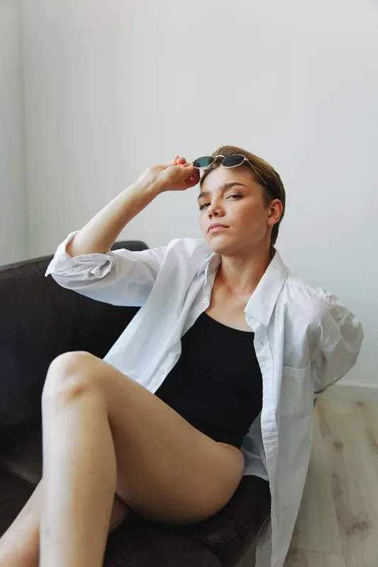 Женщина лежит на диване в очках и ёрзает