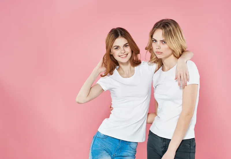 Две красивые женщины в модной одежде, гламур, дружба, веселье на розовом фоне