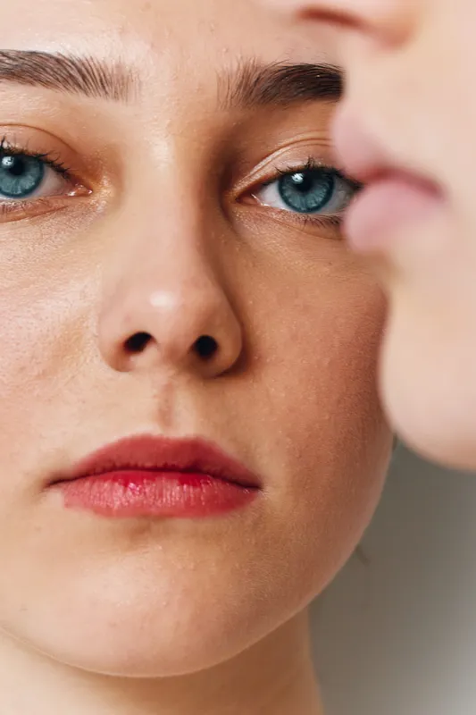 Closeup portrait of two young women with natural skin and blue eyes, focusing on facial features with clear complexion and soft light for beauty and skincare concept.