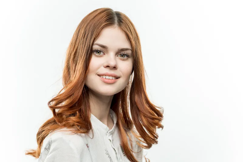 Привлекательная рыжеволосая женщина с косметикой на светлом фоне
