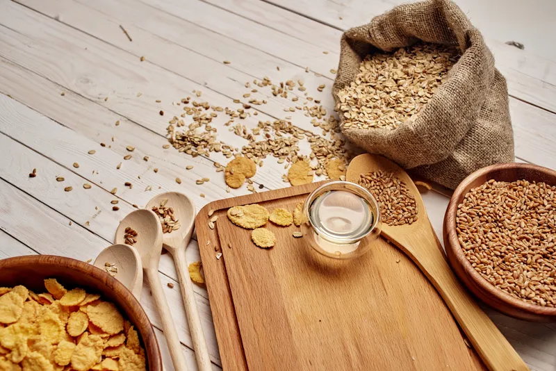 Деревянные предметы кухонной утвари, крупы, продукты на деревянном фоне