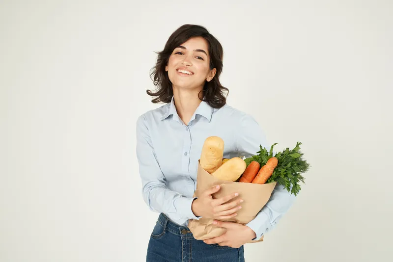 Женщина в синей рубашке упаковывает продукты для здорового питания