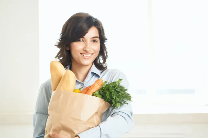 Брюнетка с букетом продуктов, овощей в супермаркете, на кухне, готовит