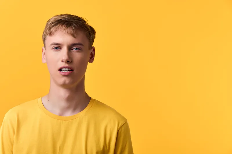 Man wearing a yellow shirt against a bright yellow studio background, presenting a bold, clean look for fashion, lifestyle, or branding projects with a confident, modern vibe