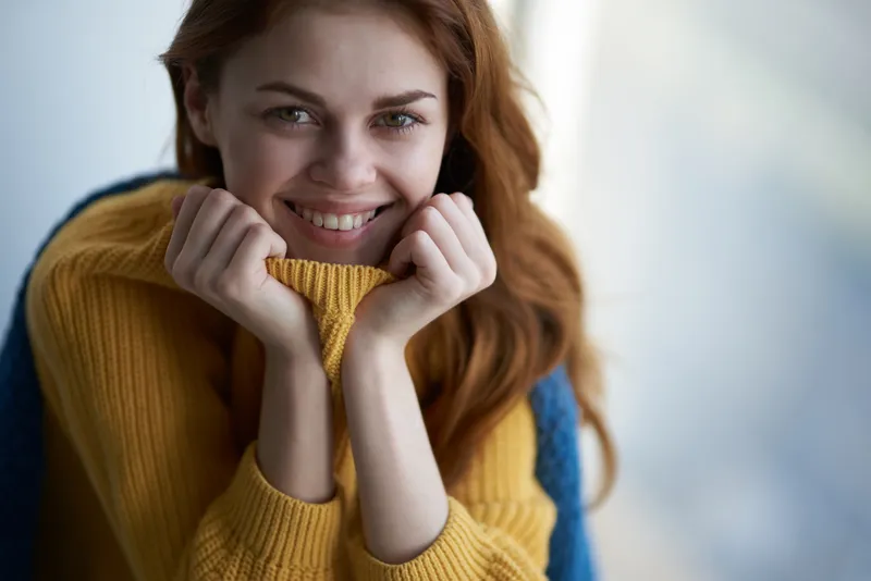 Красивая женщина с привлекательным взглядом в синей клетчатой рубашке, мечтательный взгляд