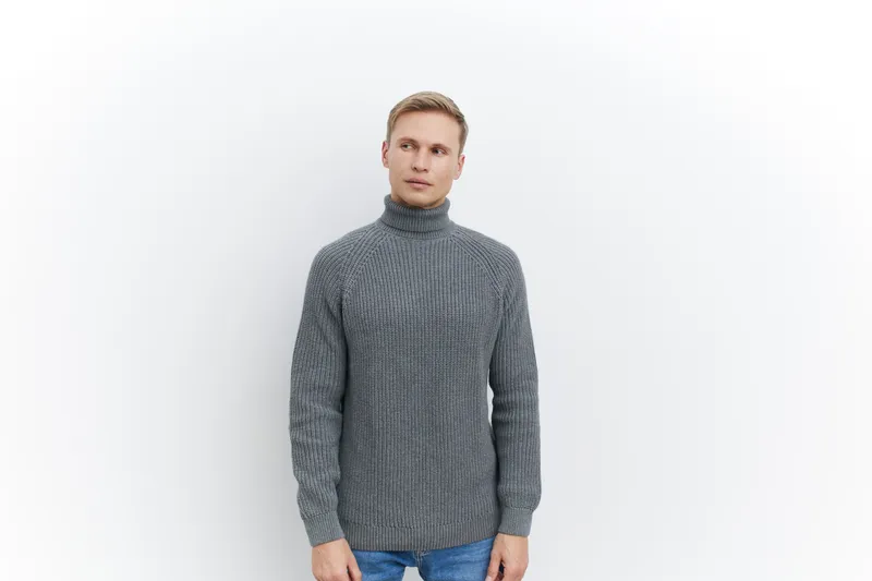 Full body portrait of a young Caucasian man with blonde hair wearing a gray knitted turtleneck sweater, looking at camera, standing against plain white background, studio shot, casual fashion, men lif