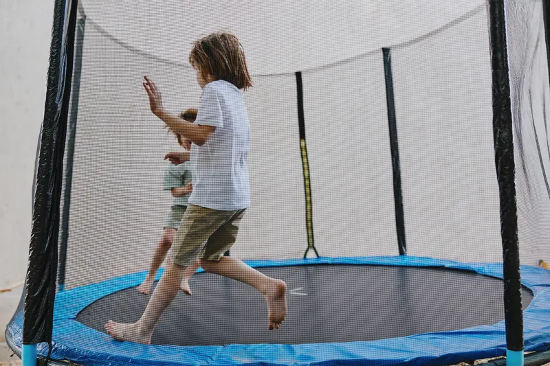 Active children jumping on a trampoline, enjoying playful moments and laughter in a fun atmosphere. Perfect for capturing the joy of childhood and outdoor activities.