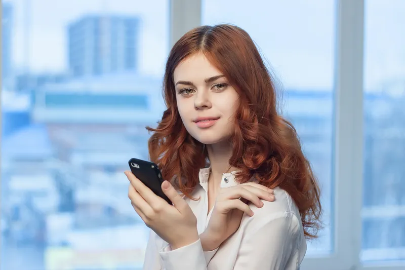 Женщина в рубашке с телефоном в руке, технологии, профессионализм