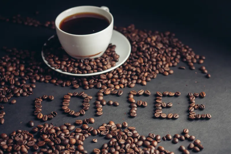 Чашка кофе для завтрака и надпись «arabica» на столе