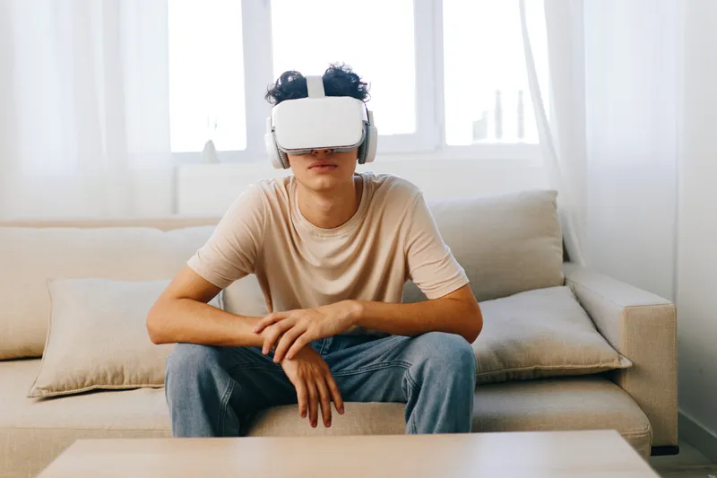 Молодой человек погружается в опыт виртуальной реальности в VR-гарнитуре