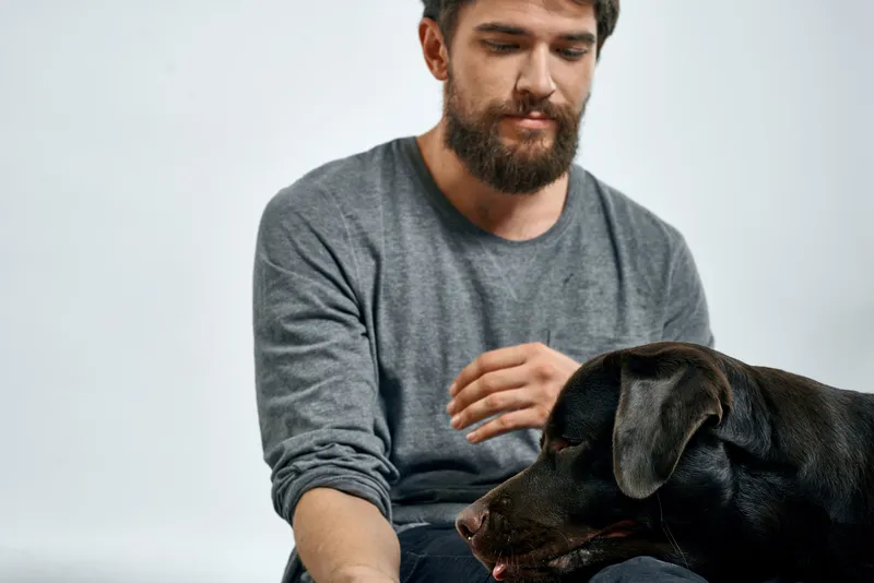 Счастливый хозяин со своим питомцем — черной собакой