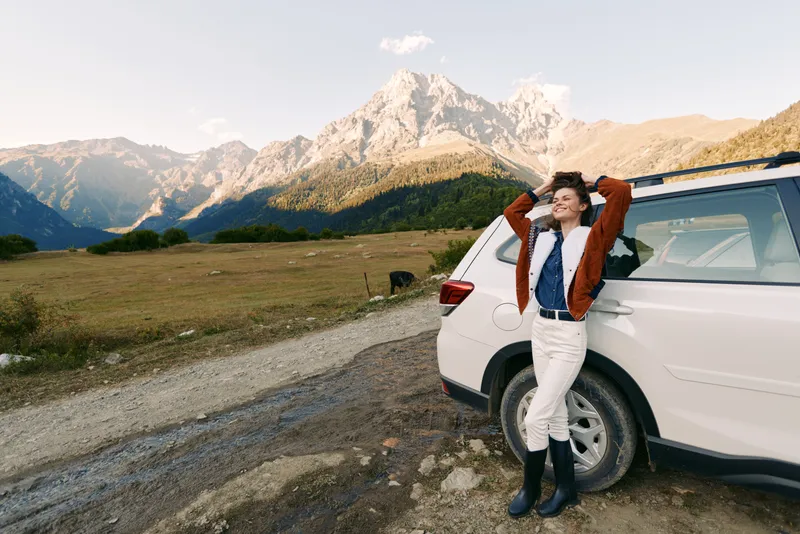Woman, car, mountains, nature, road, travel, landscape, adventure - Young woman leans on white SUV on dirt road by alpine mountains, enjoying outdoor travel, scenic landscape and weekend adventure.